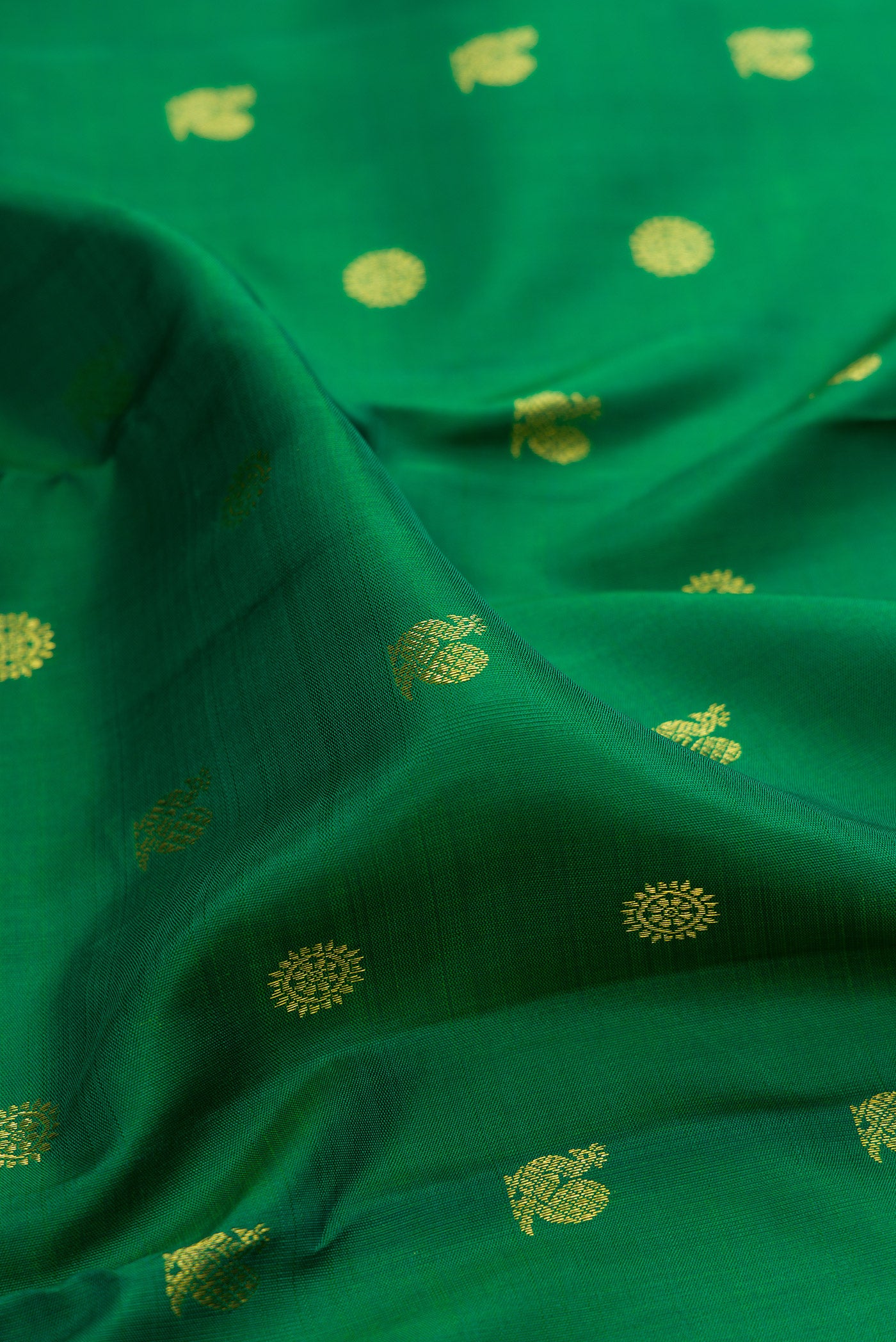 Close up of Green Kanjivaram Silk Saree with Zari Butta on the body and Zari Border.  displaying folds