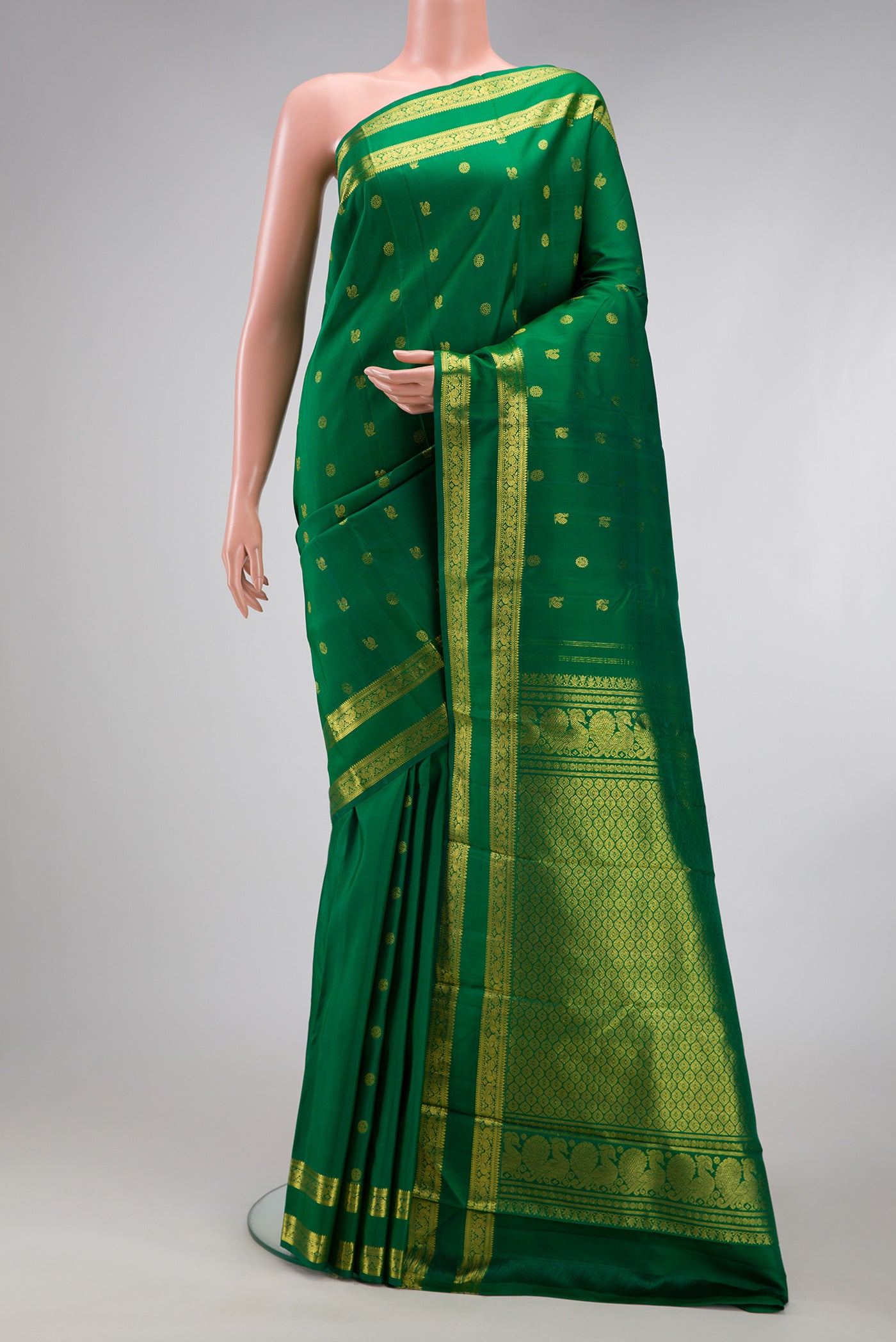 Green Kanjivaram Silk Saree with Zari Butta on the body and Zari Border.  displayed on a mannequin