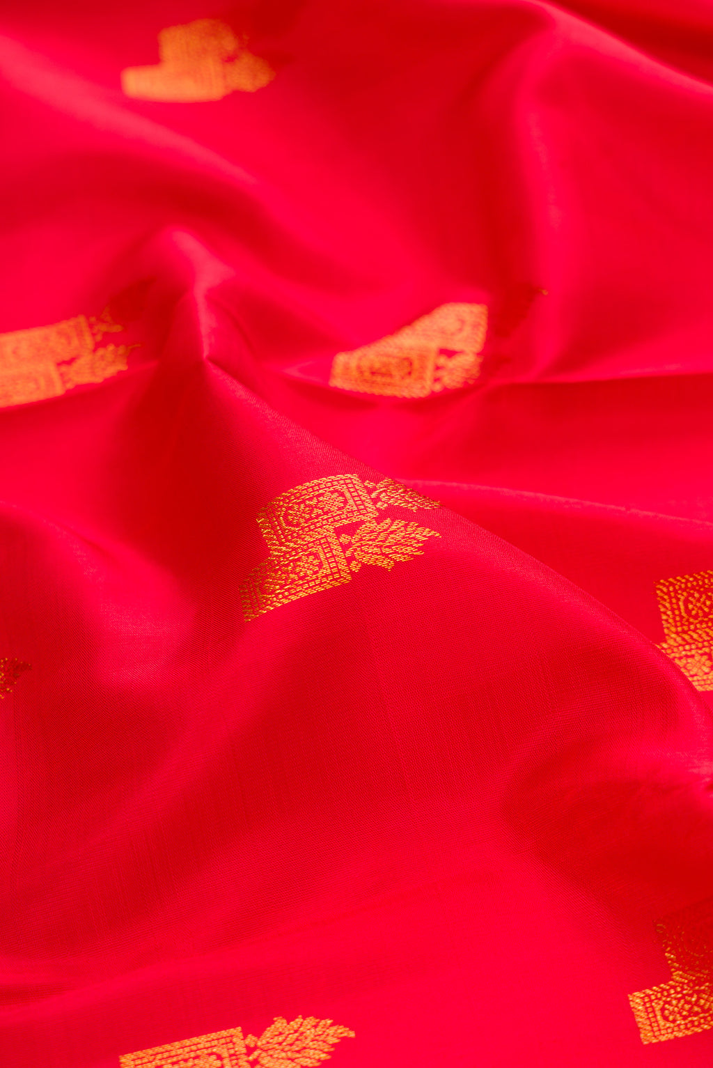 Close up of Red Kanchipuram Silk Saree with Zari Butta on the body and Zari Border.  displaying folds