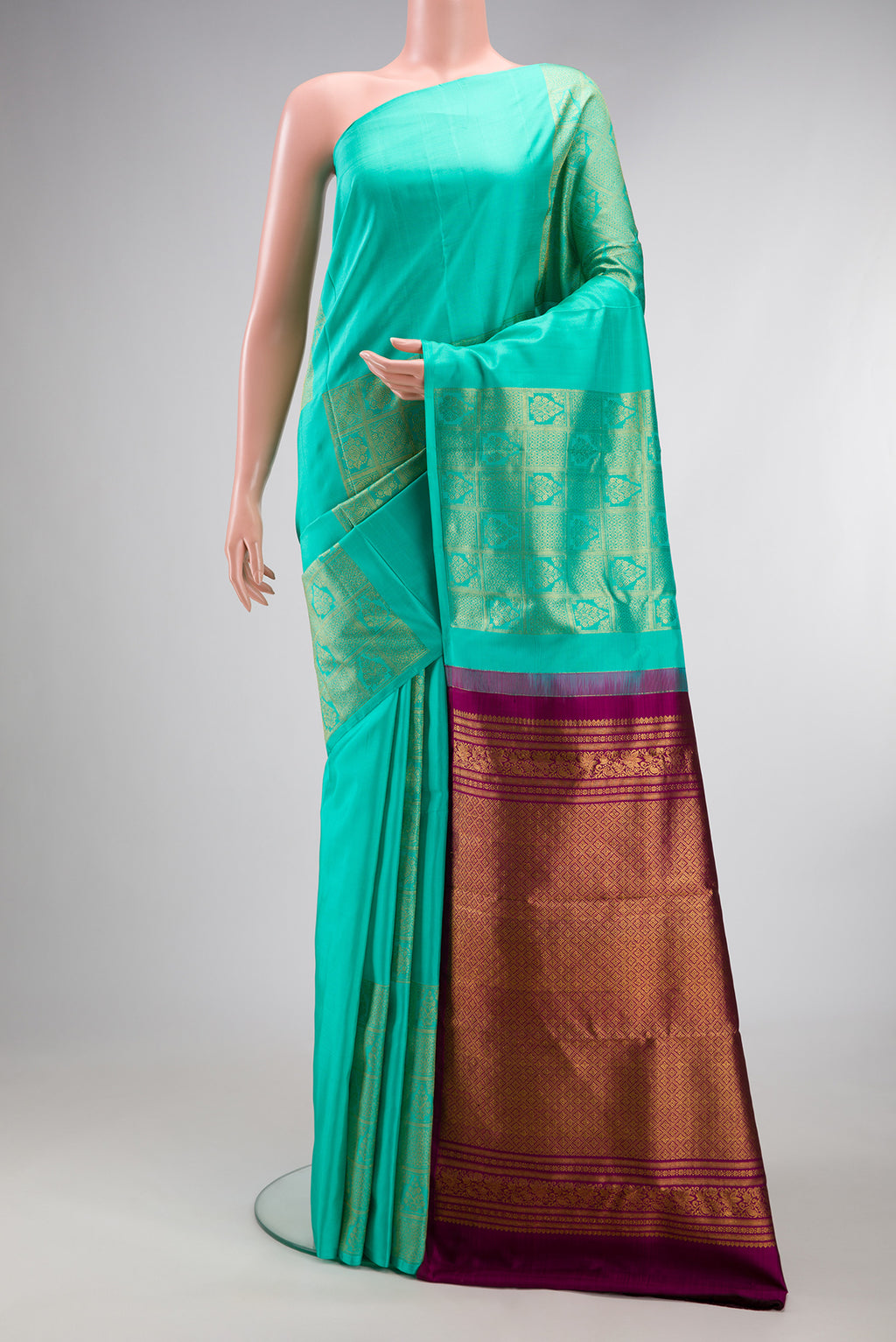 Pure Silk Turquoise Kanjivaram Saree with Zari Butta on the body and Without Border.  displayed on a mannequin