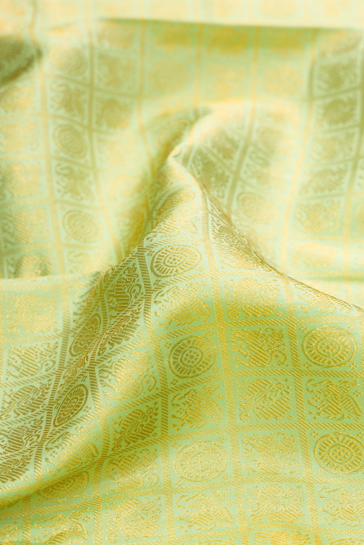 Close up of Pure Silk Pista Green Kanjivaram Saree with Zari Brocade on the body and Zari Border.  displaying folds