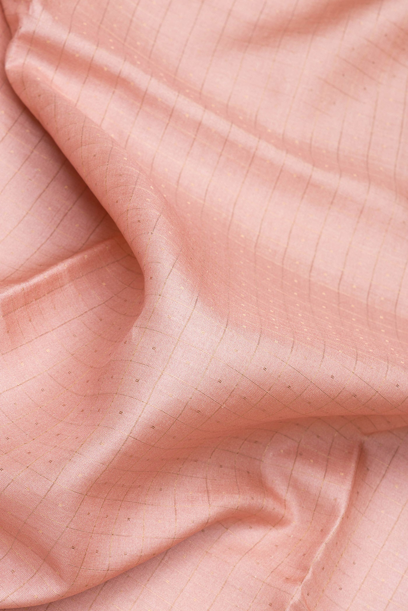 Close up of Rose Gold Tussar Silk Saree with Checked design on the body and Fancy Border.  displaying folds