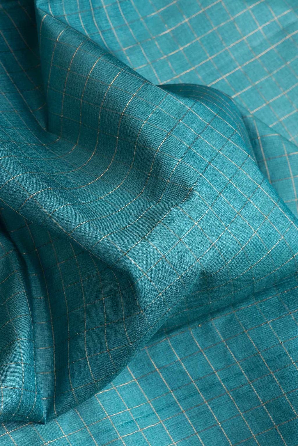 Close up of Peacock Blue Dual Tone Tussar Silk Saree with Printed design on the body and Zari Border.  displaying folds