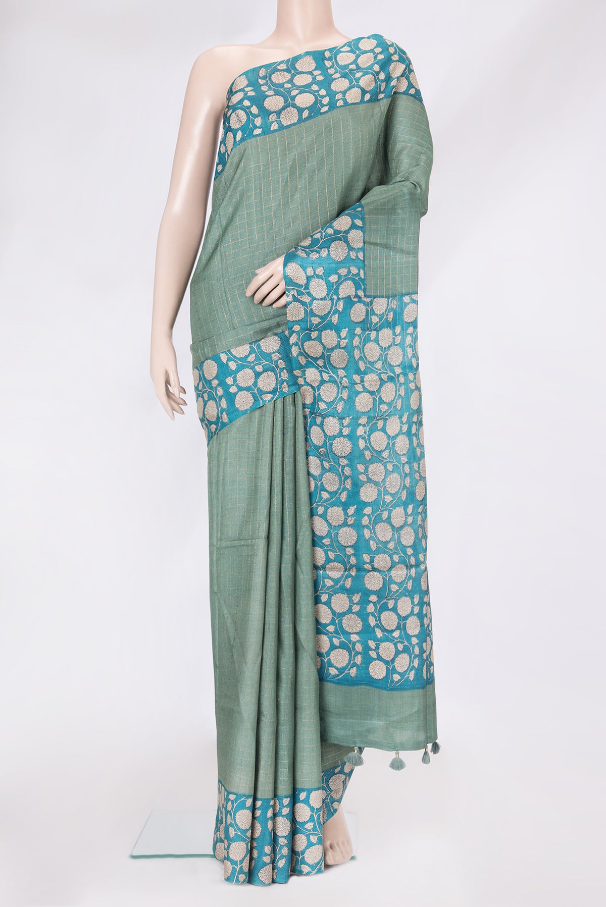 Green Tussar Silk Saree with Checked design on the body and Printed Border.  displayed on a mannequin