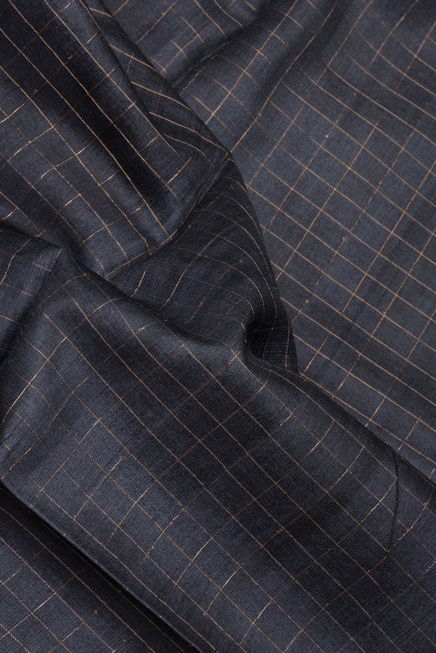 Close up of Grey Tussar Silk Saree with Checked design on the body and Printed Border.  displaying folds