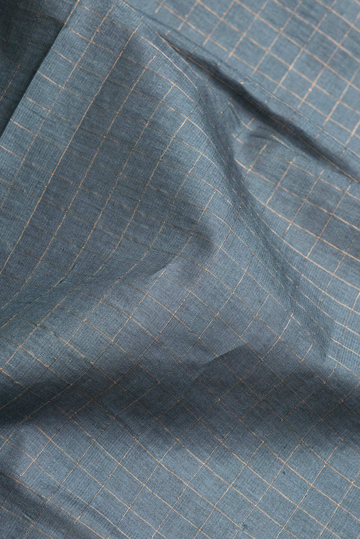 Close up of Grey Dual Tone Tussar Silk Saree with Checked design on the body and Printed Border.  displaying folds