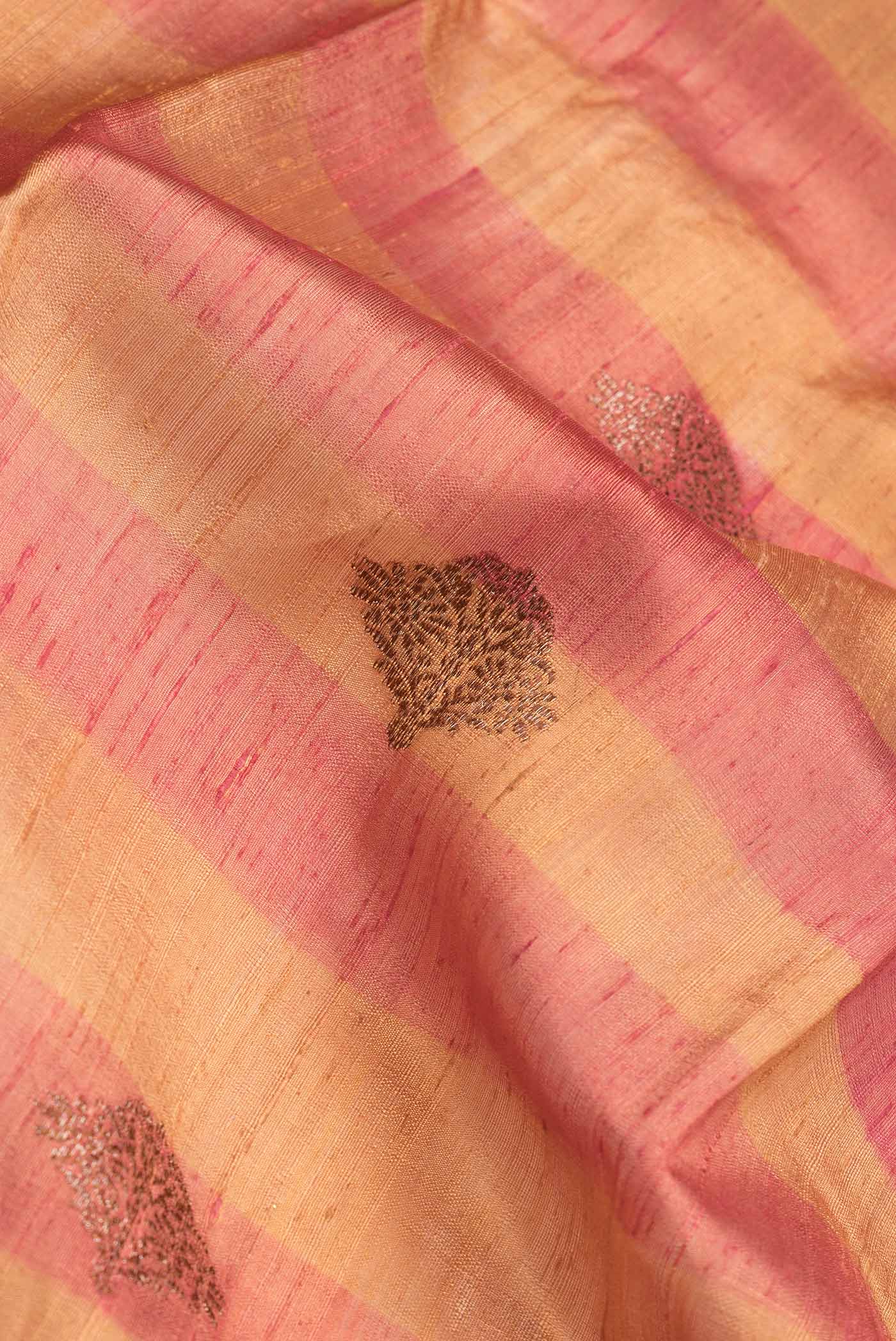 Close up of Beige Dual Tone Tussar Saree with Zari Butta on the body and Zari Border.  displaying folds