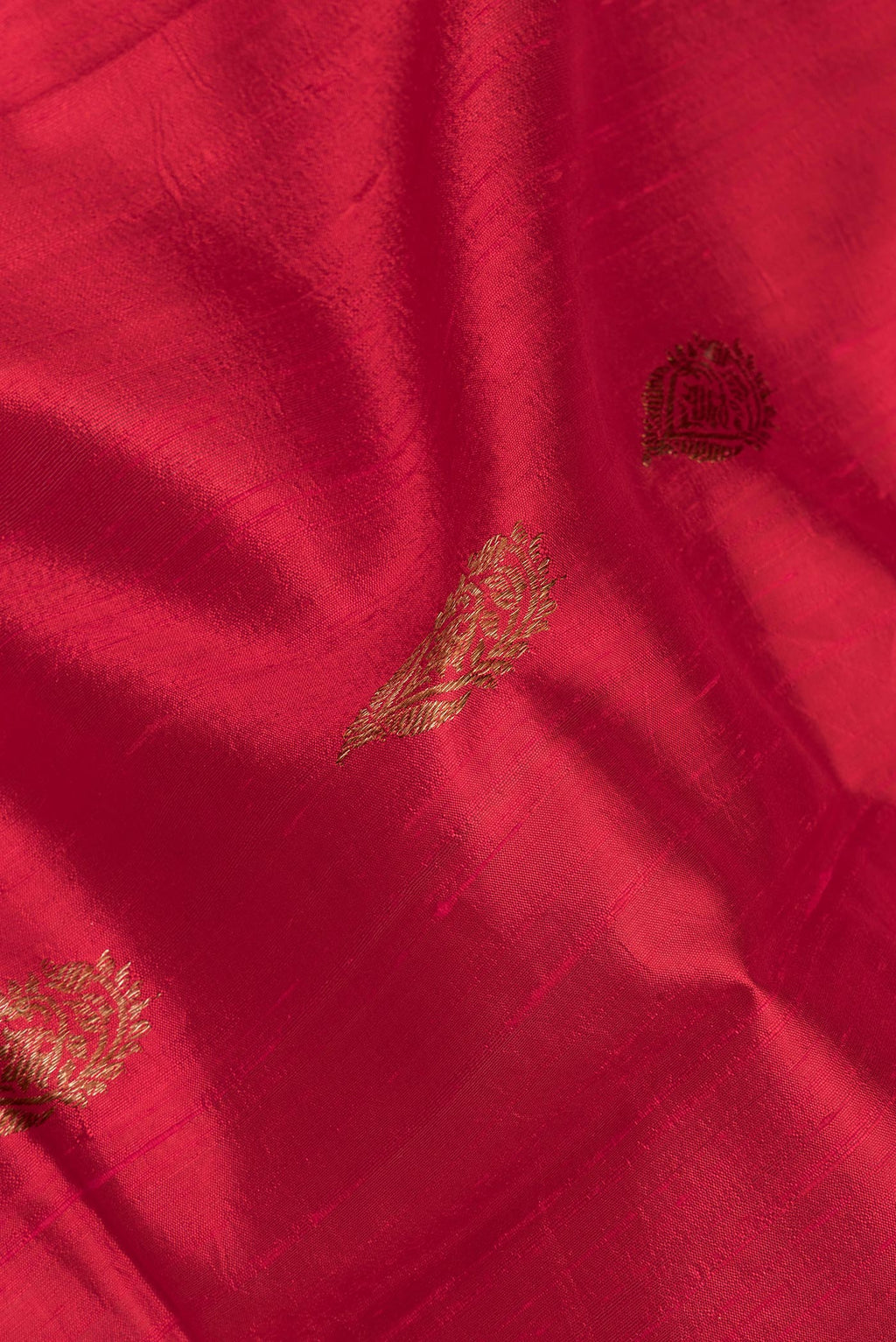 Close up of Pure Silk Red Tussar Saree with Zari Butta on the body and Fancy Border.  displaying folds