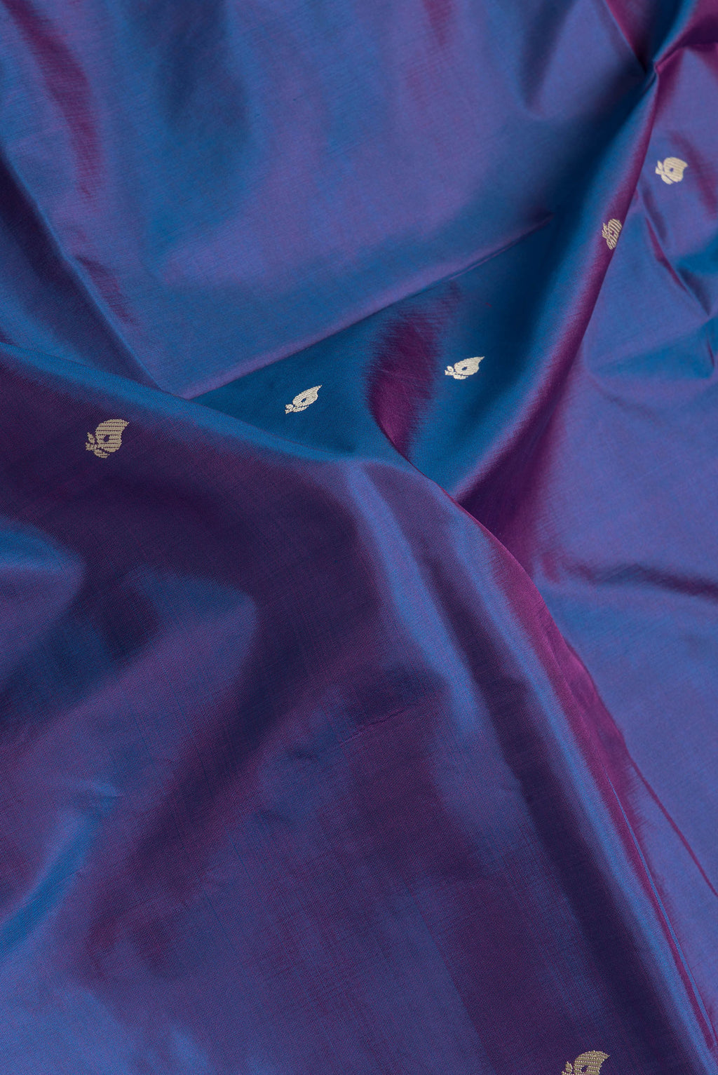 Close up of Peacock Blue Dual Tone Banarasi Silk Saree with Thread Butta on the body and Thread Border.  displaying folds