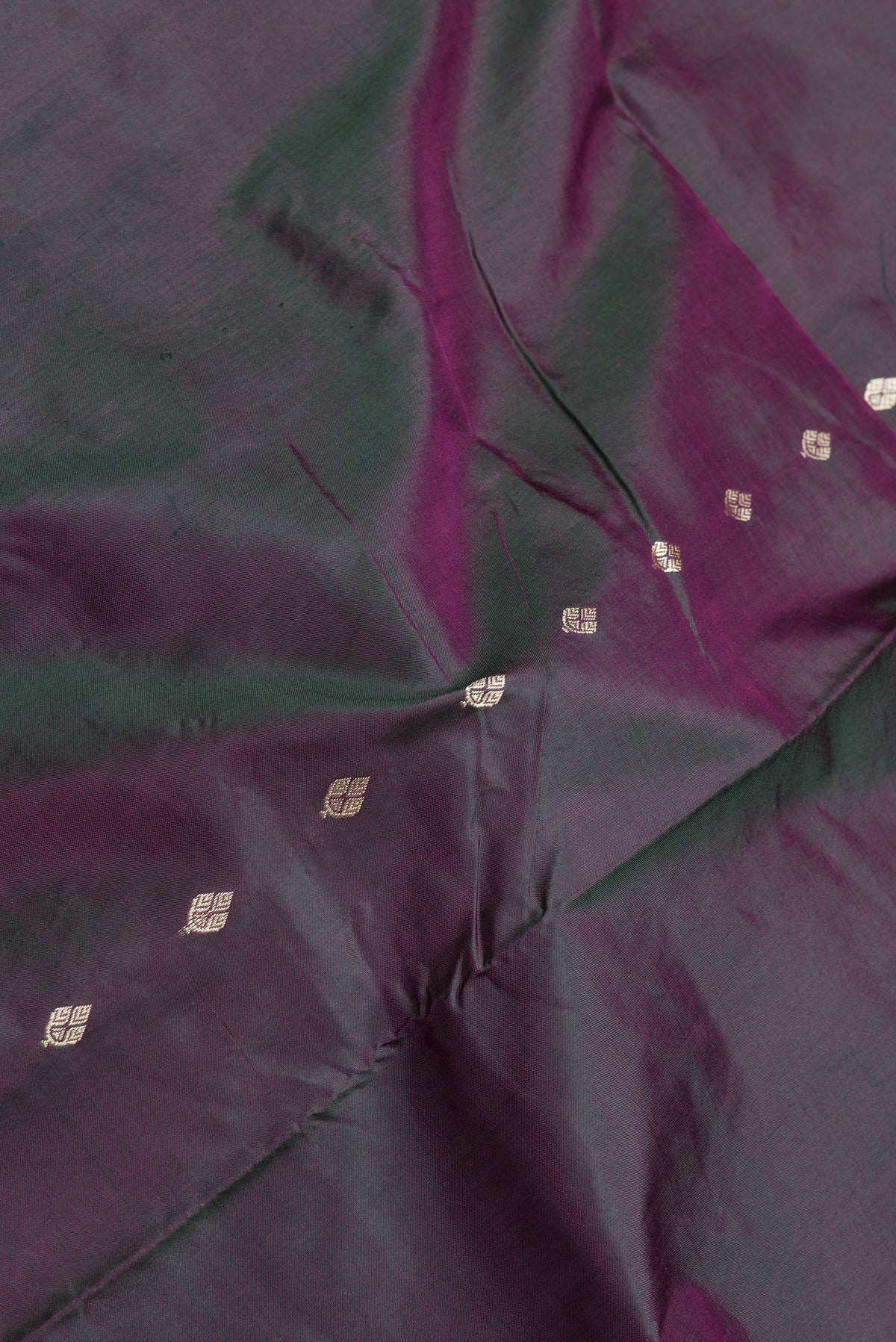 Close up of Green Dual Tone Banarasi Silk Saree with Thread Butta on the body and Thread Border.  displaying folds