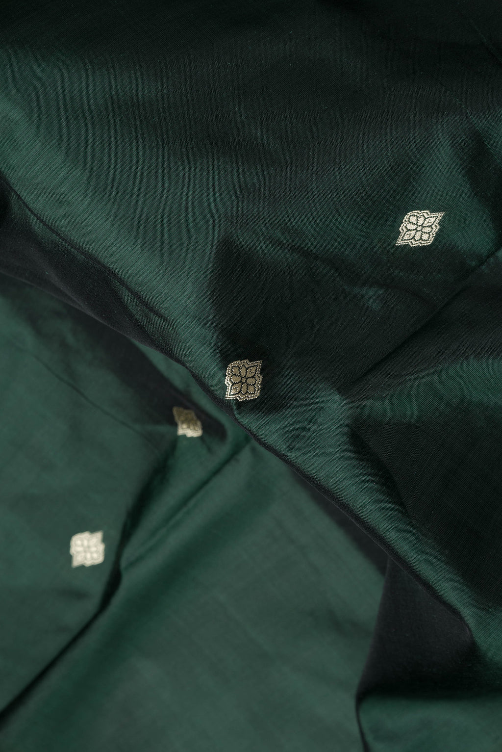 Close up of Bottle Green Dual Tone Banarasi Silk Saree with Thread Butta on the body and Thread Border.  displaying folds