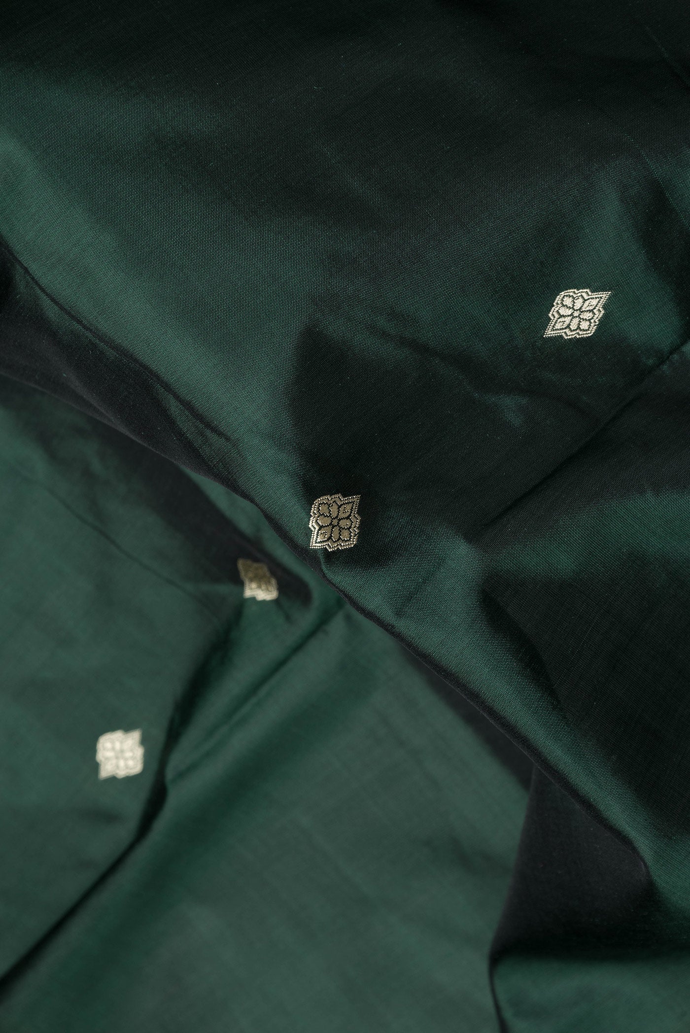 Close up of Bottle Green Dual Tone Banarasi Silk Saree with Thread Butta on the body and Thread Border.  displaying folds