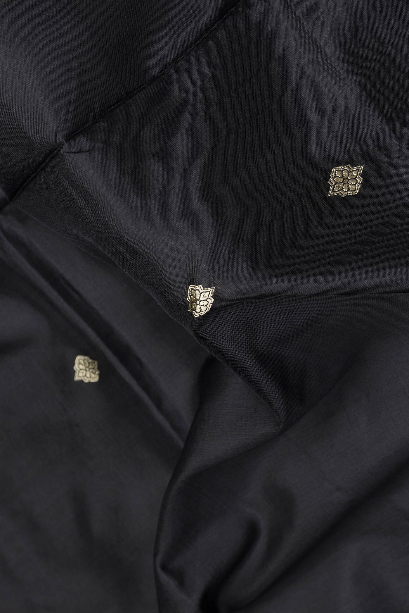 Close up of Black Dual Tone Banarasi Silk Saree with Thread Butta on the body and Thread Border.  displaying folds
