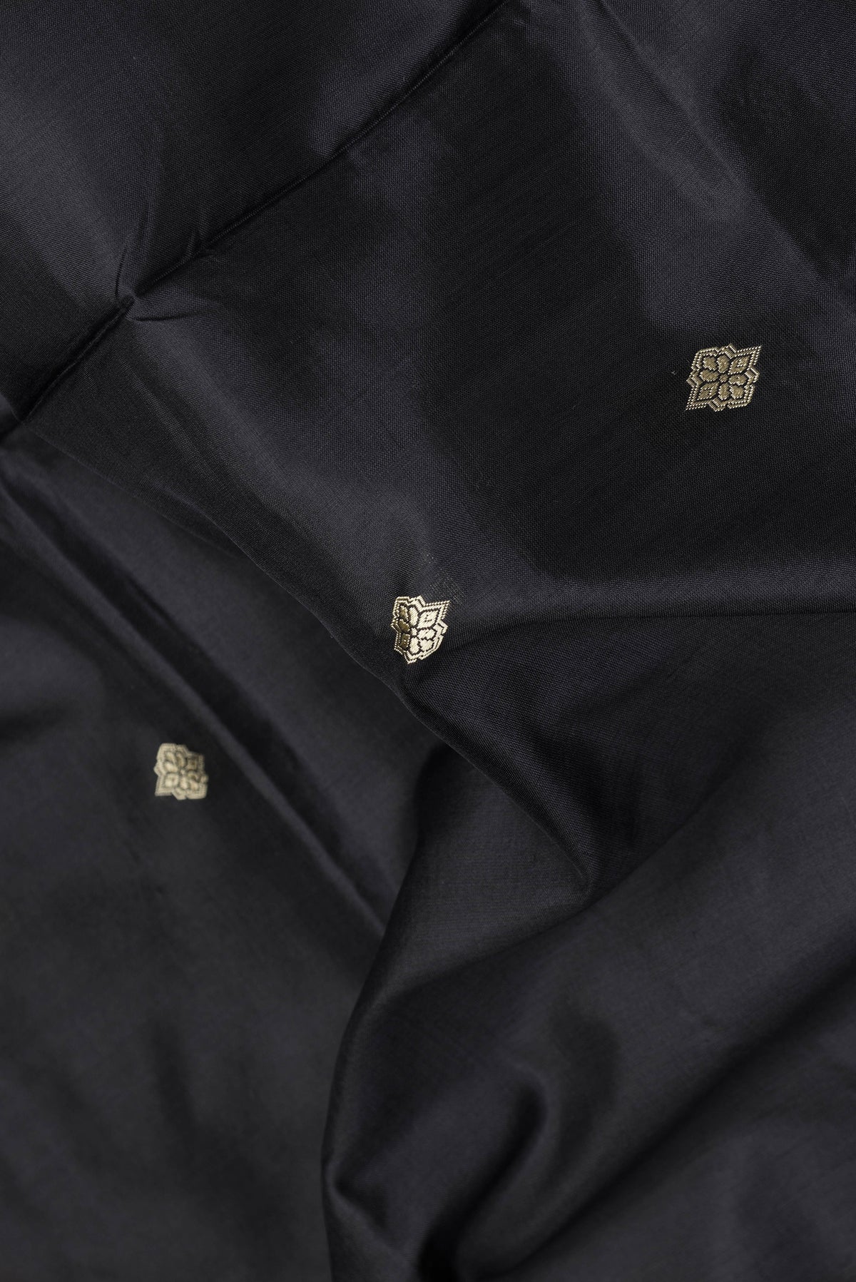 Close up of Black Dual Tone Banarasi Silk Saree with Thread Butta on the body and Thread Border.  displaying folds