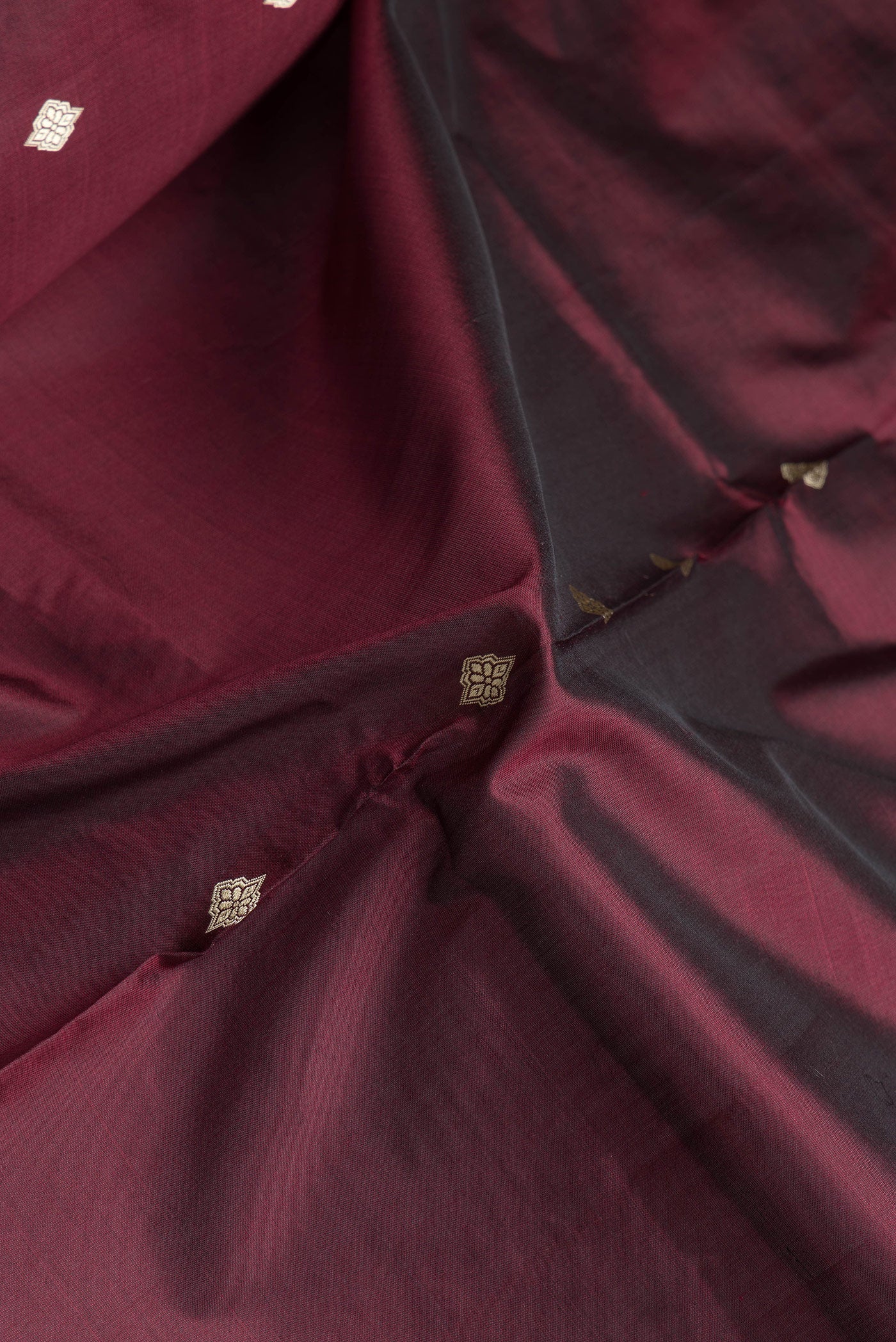 Close up of Brown Dual Tone Banarasi Silk Saree with Thread Butta on the body and Thread Border.  displaying folds