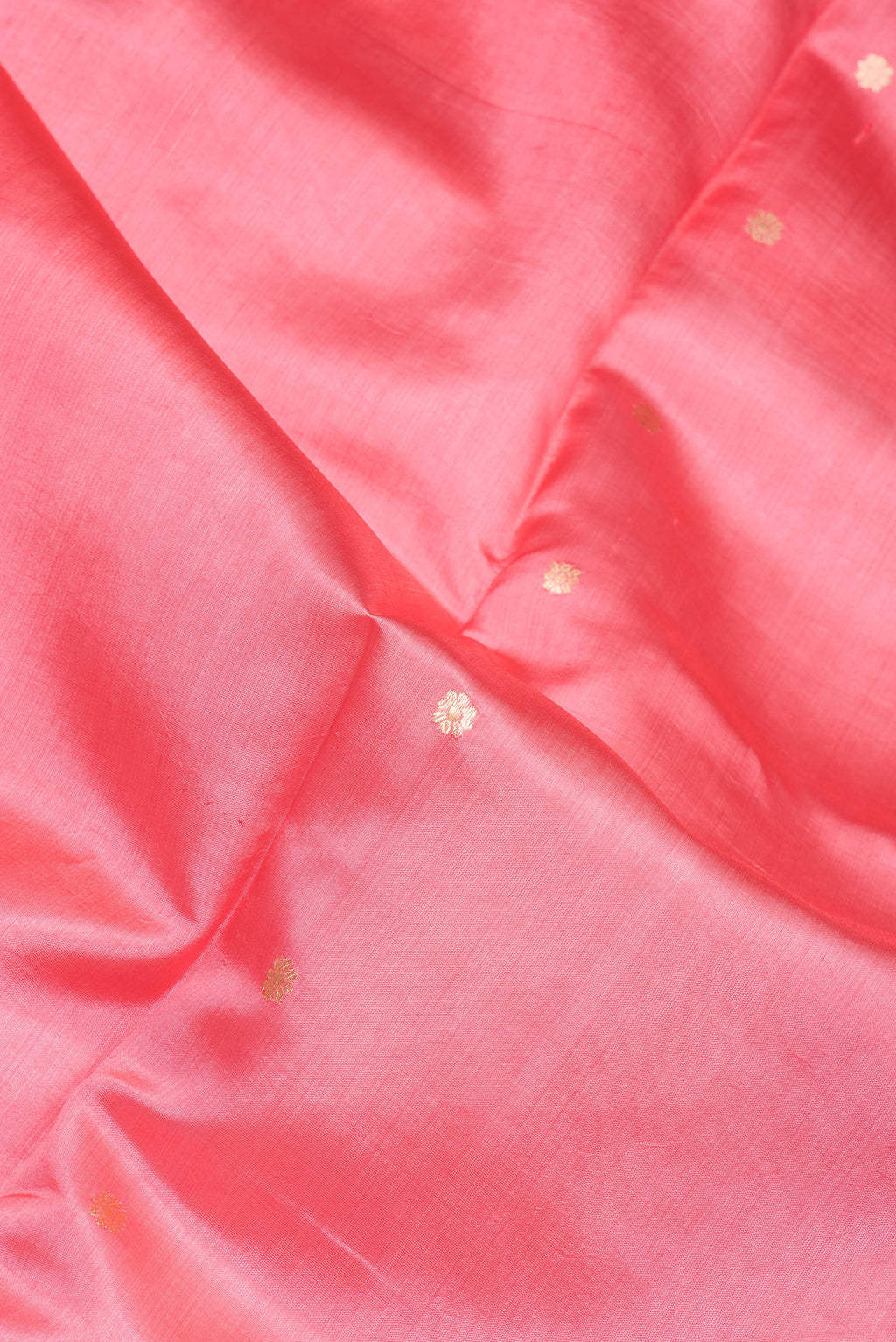 Close up of Coral Tussar Silk Saree with Zari Butta on the body and Fancy Border.  displaying folds