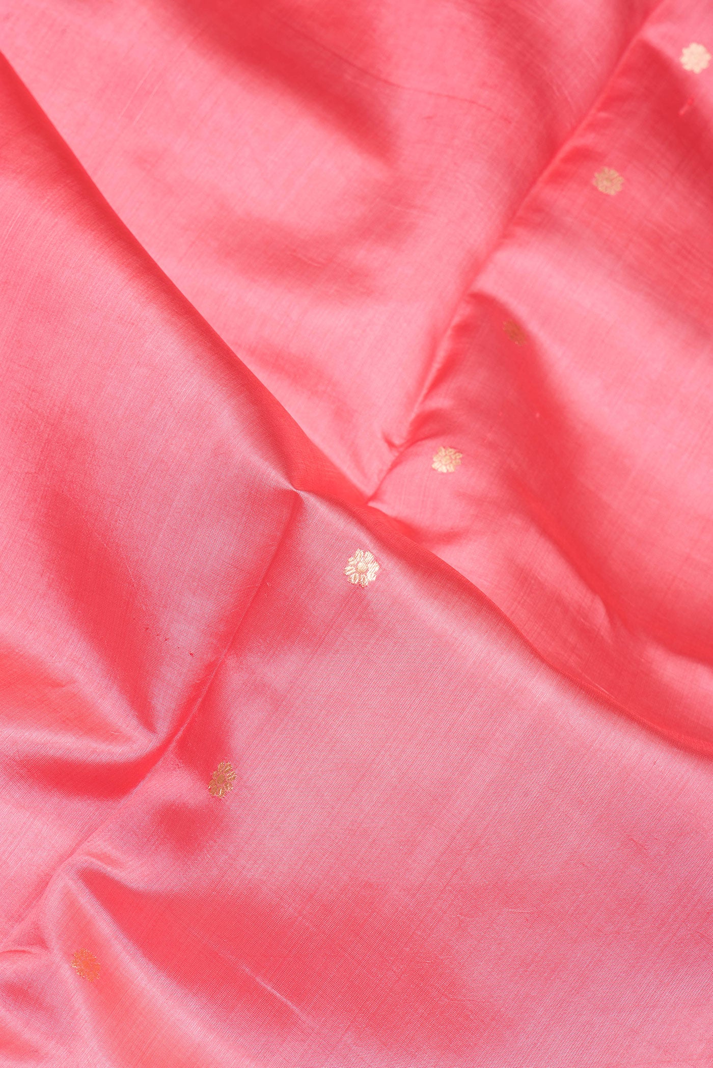 Close up of Coral Tussar Silk Saree with Zari Butta on the body and Fancy Border.  displaying folds