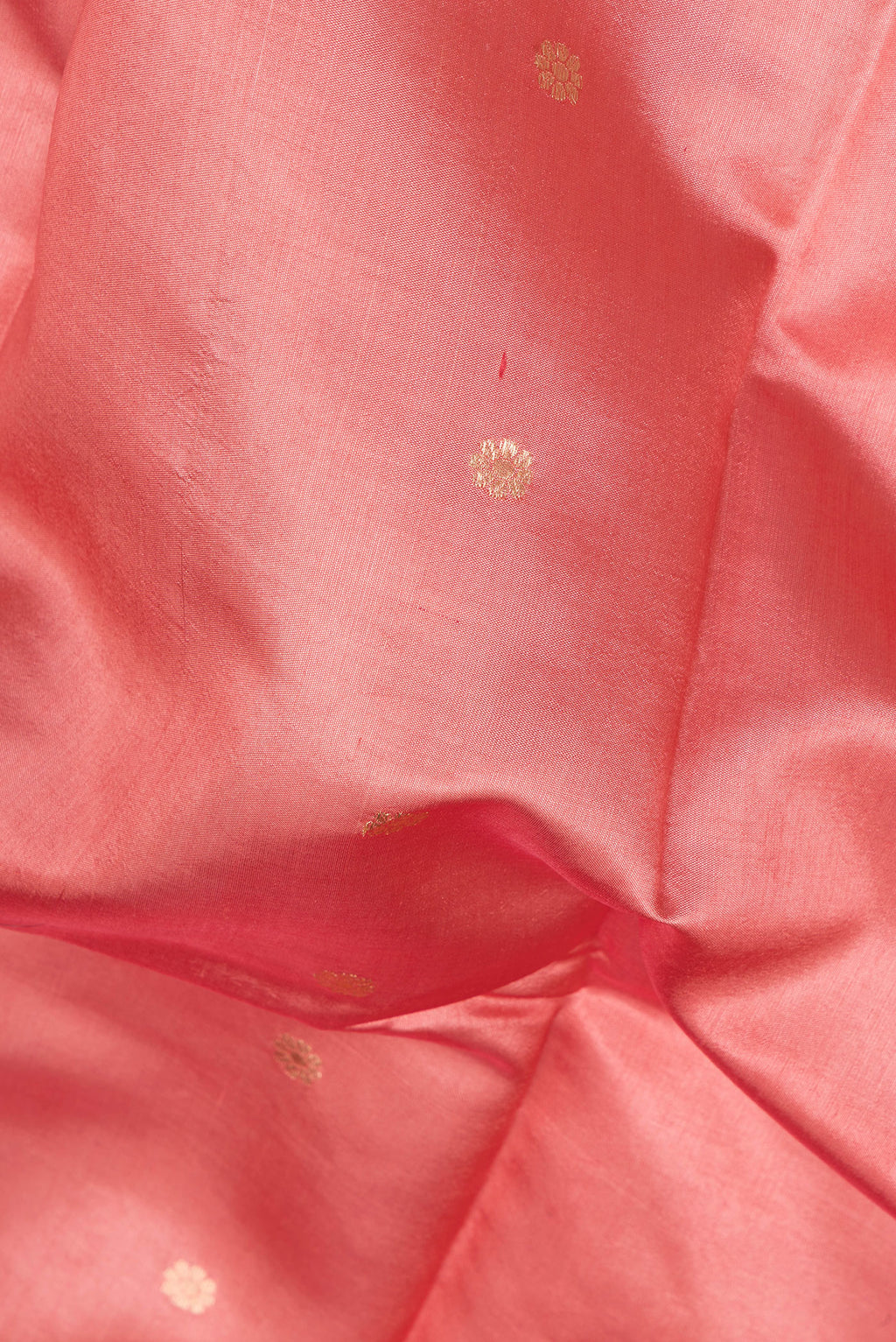 Close up of Peach Tussar Silk Saree with Zari Butta on the body and Fancy Border.  displaying folds
