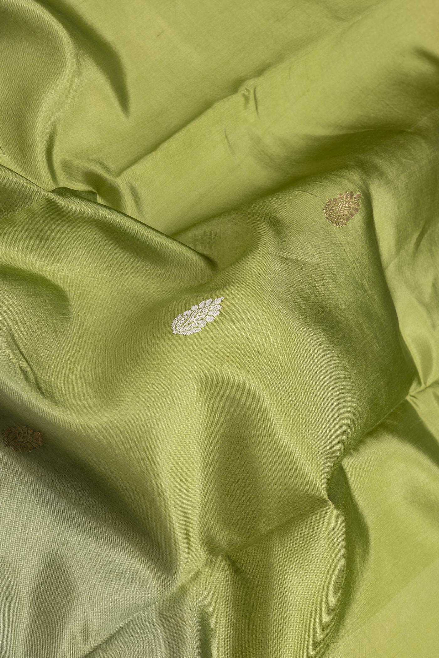 Close up of Pista Green Dual Tone Tussar Silk Saree with Zig Zag design on the body and Plain Border.  displaying folds