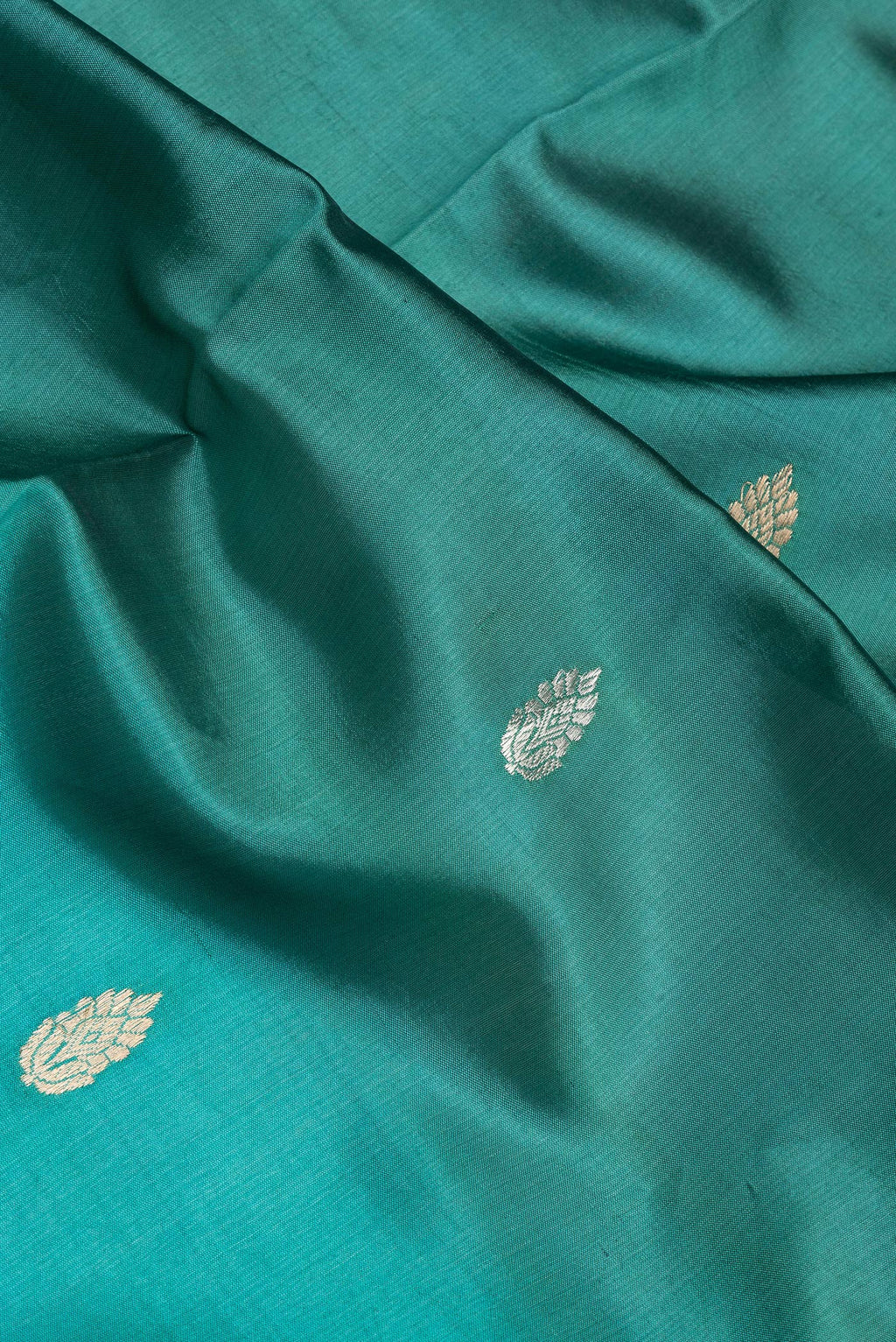 Close up of Peacock Blue Tussar Silk Saree with Stripes on the body and Plain Border.  displaying folds