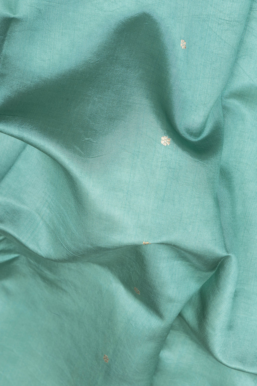 Close up of Green Tussar Silk Saree with Zari Butta on the body and Fancy Border.  displaying folds