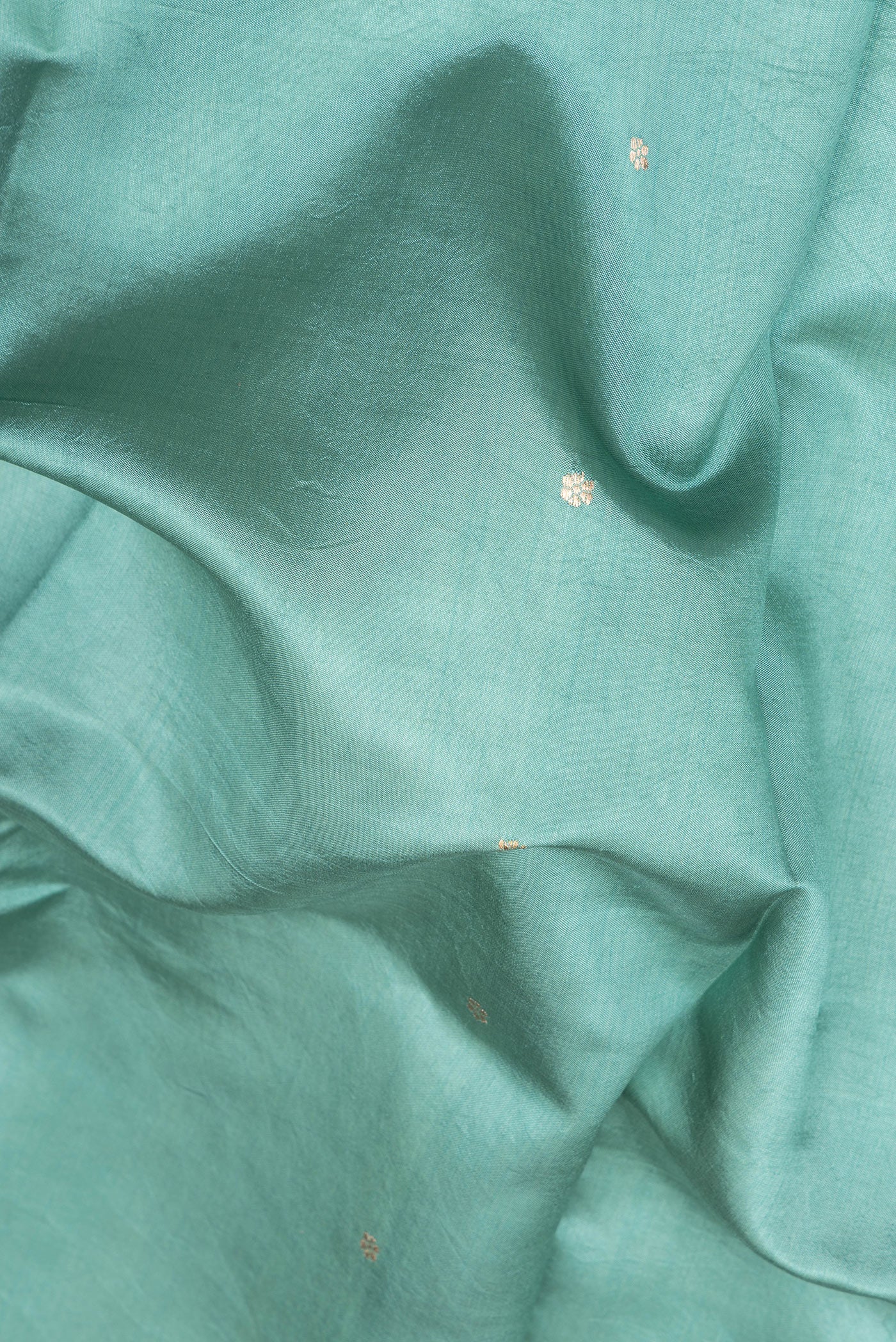 Close up of Green Tussar Silk Saree with Zari Butta on the body and Fancy Border.  displaying folds