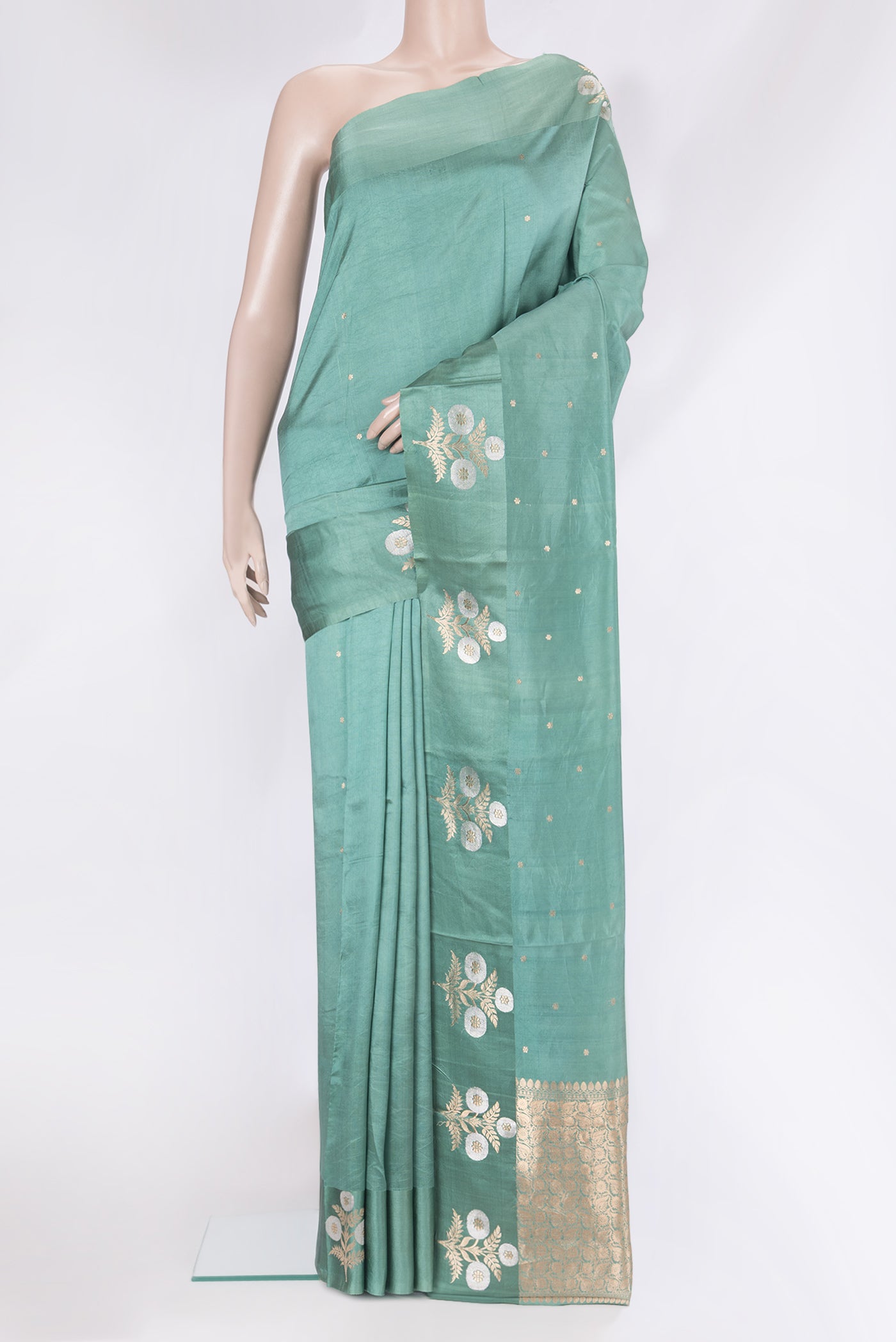 Green Tussar Silk Saree with Zari Butta on the body and Fancy Border.  displayed on a mannequin