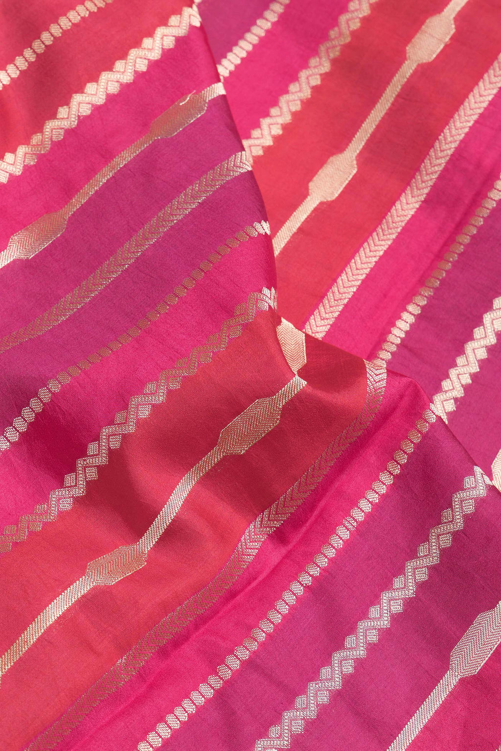 Close up of Red,Purple and Pink Color Tussar Silk Saree with Zari Brocade on the body and Zari Border.  displaying folds