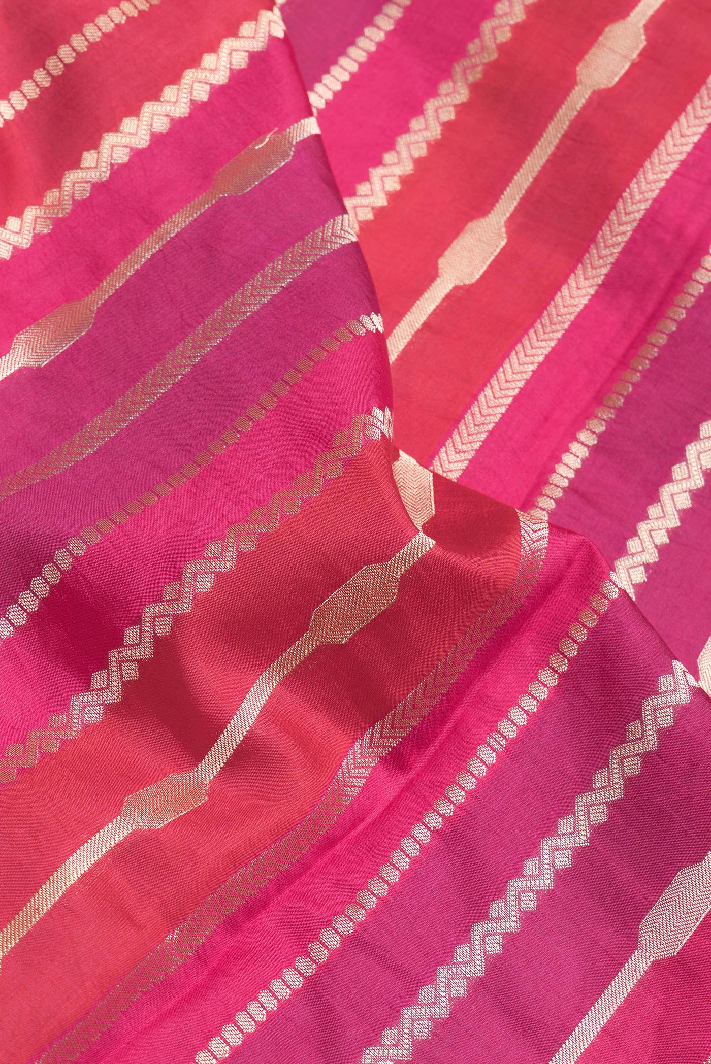 Close up of Red,Purple and Pink Color Tussar Silk Saree with Zari Brocade on the body and Zari Border.  displaying folds