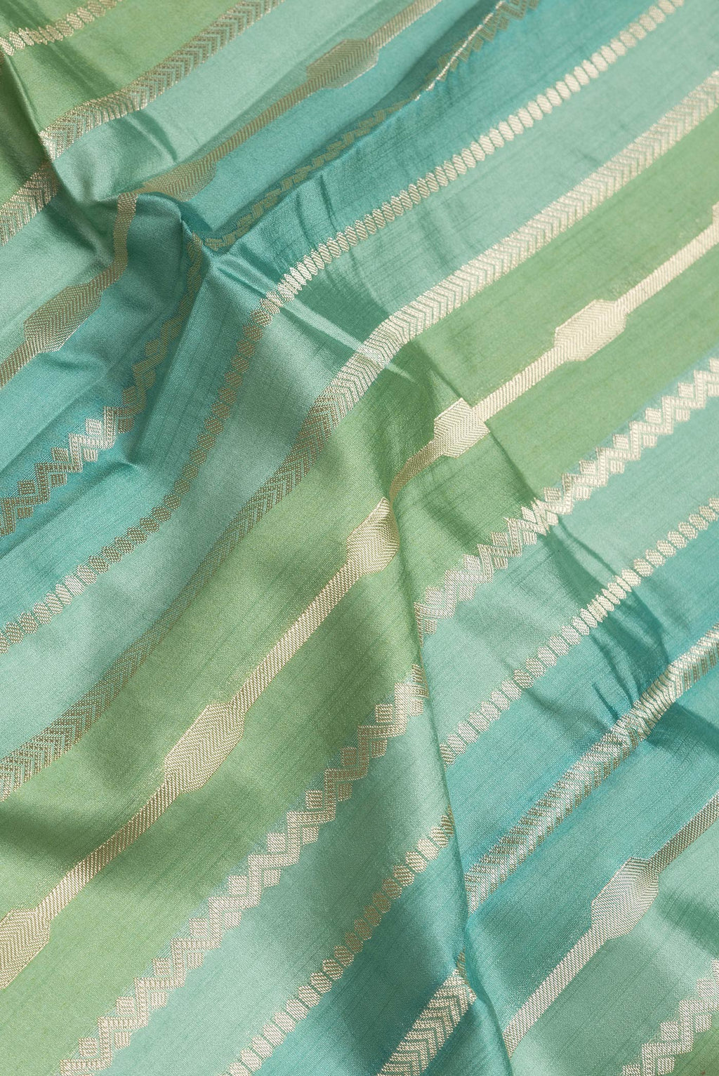 Close up of Pista Green Dual Tone Tussar Silk Saree with Stripes on the body and Zari Border.  displaying folds