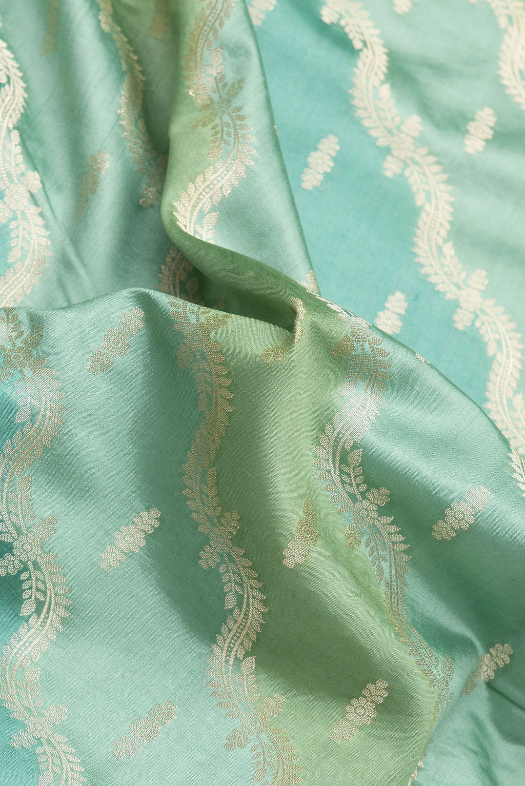 Close up of Green Dual Tone Banarasi Raw Silk Saree with Zari Brocade on the body and Zari Border.  displaying folds