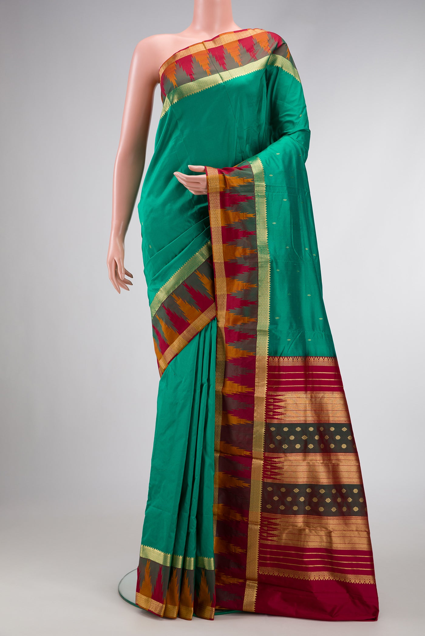 Green Dual Tone Kanchipuram Silk Saree with Zari Butta on the body and Zari Border.  displayed on a mannequin