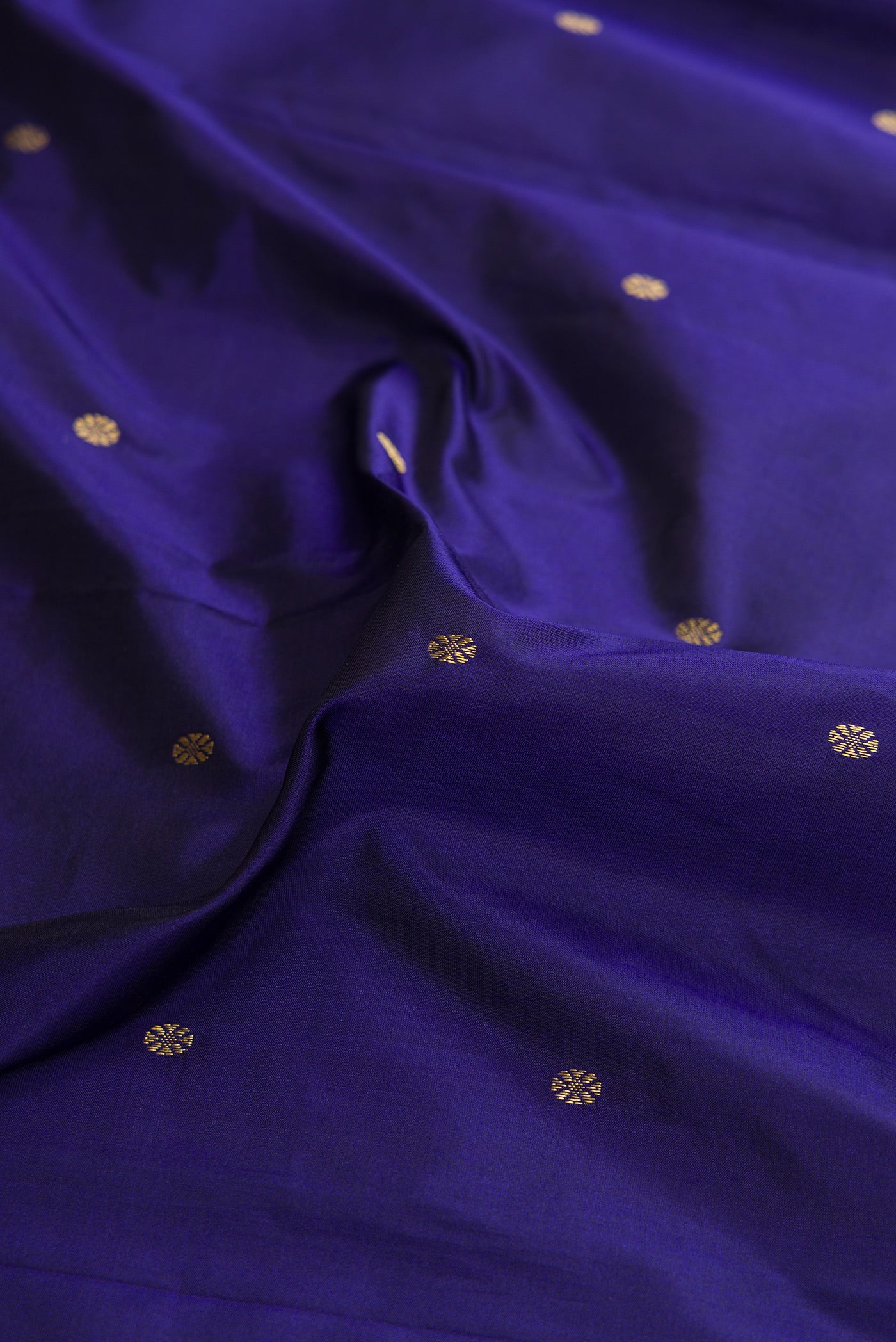 Close up of Violet Dual Tone Kanchipuram Silk Saree with Zari Butta on the body and Zari Border.  displaying folds