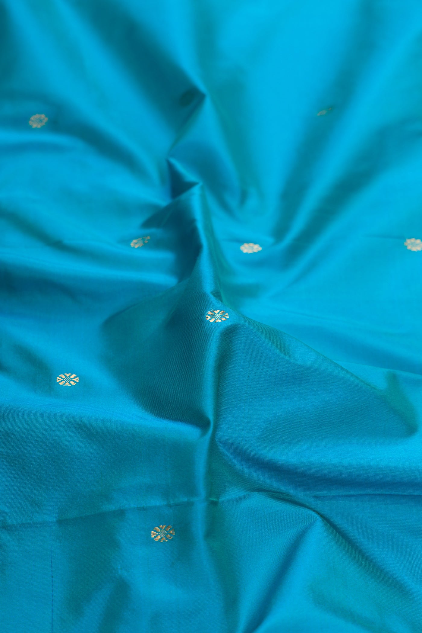 Close up of Sky Blue Dual Tone Kanchipuram Silk Saree with Zari Butta on the body and Temple Border.  displaying folds