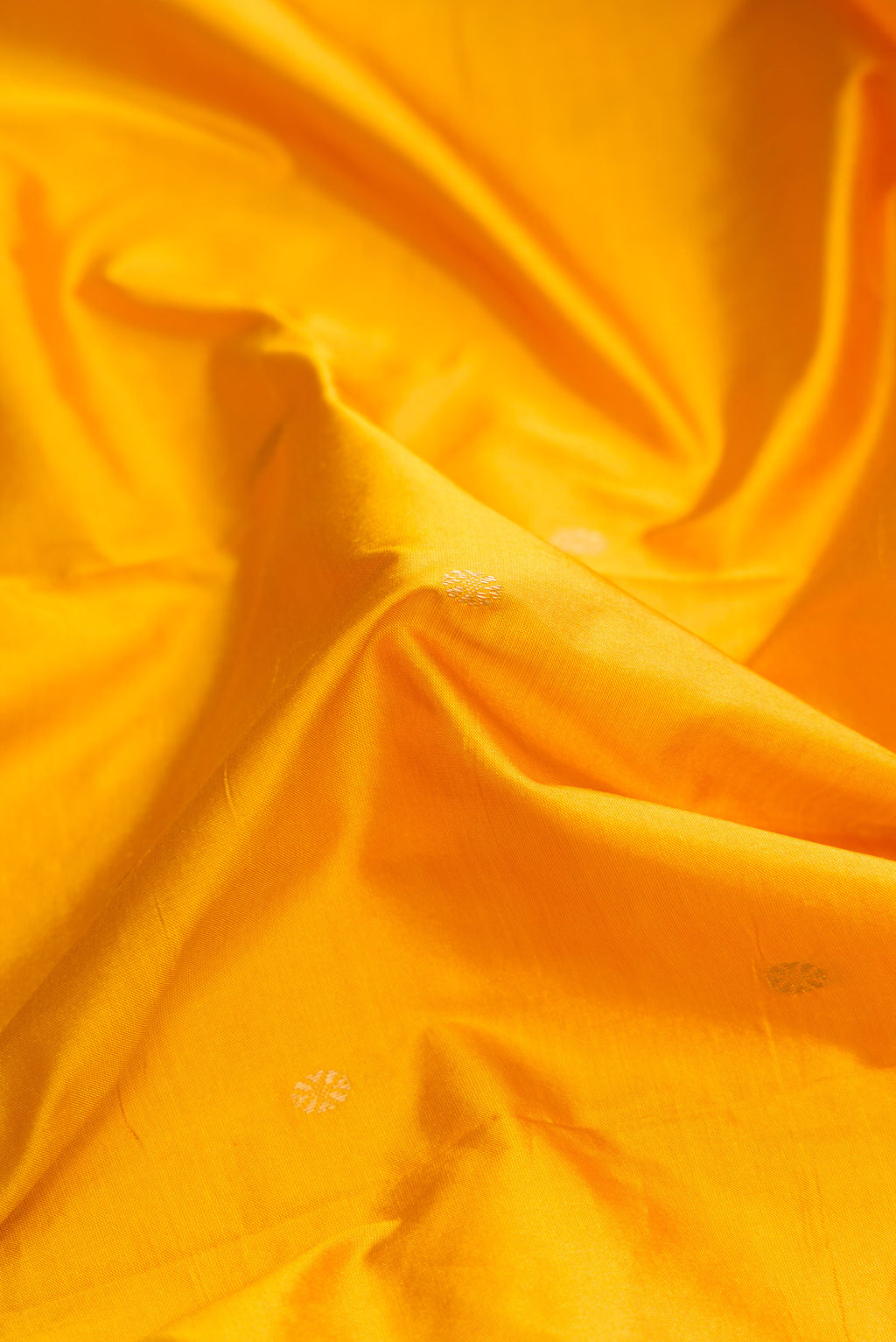 Close up of Yellow Dual Tone Kanchipuram Silk Saree with Zari Butta on the body and Temple Border.  displaying folds