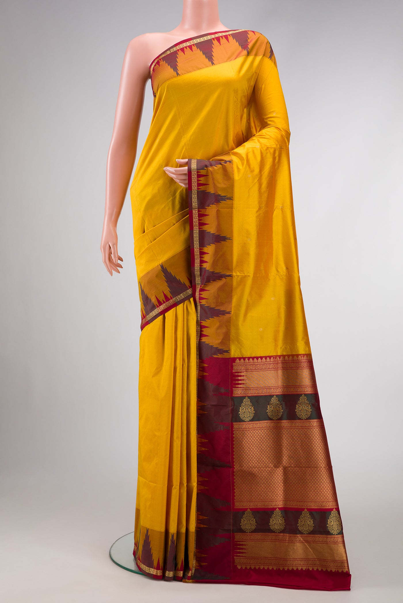 Yellow Dual Tone Kanchipuram Silk Saree with Zari Butta on the body and Temple Border.  displayed on a mannequin
