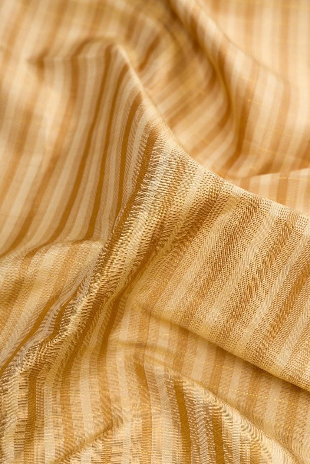 Close up of Dark Beige Dual Tone Kanchipuram Silk Saree with Checked design on the body and Zari Border.  displaying folds