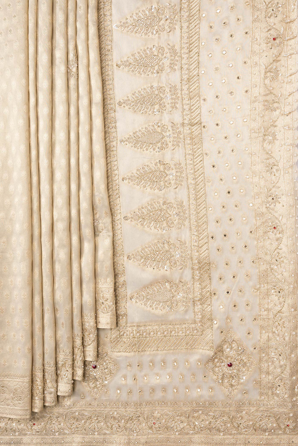 Pleats and pallu of Beige Dual Tone Organza Silk Saree with Zari Brocade on the body and Embroidery Border. 