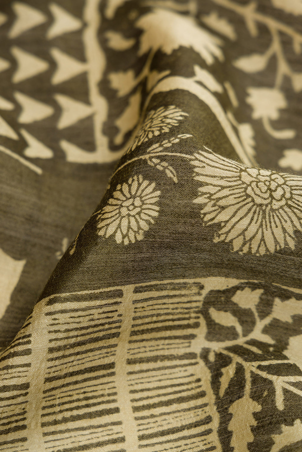 Close up of Mehandi Green Dual Tone Tussar Silk Saree with Printed design on the body and Zari Border.  displaying folds