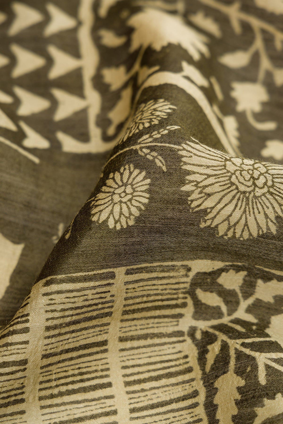 Close up of Mehandi Green Dual Tone Tussar Silk Saree with Printed design on the body and Zari Border.  displaying folds