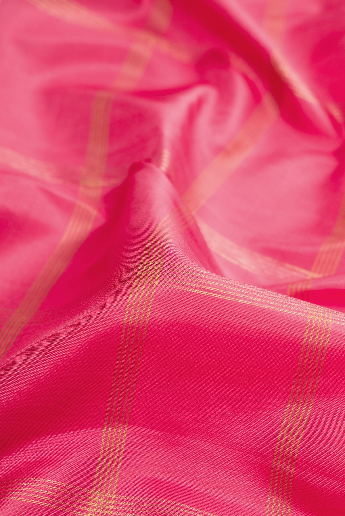 Close up of Pink Kanjivaram Silk Saree with Checked design on the body and Temple Border.  displaying folds