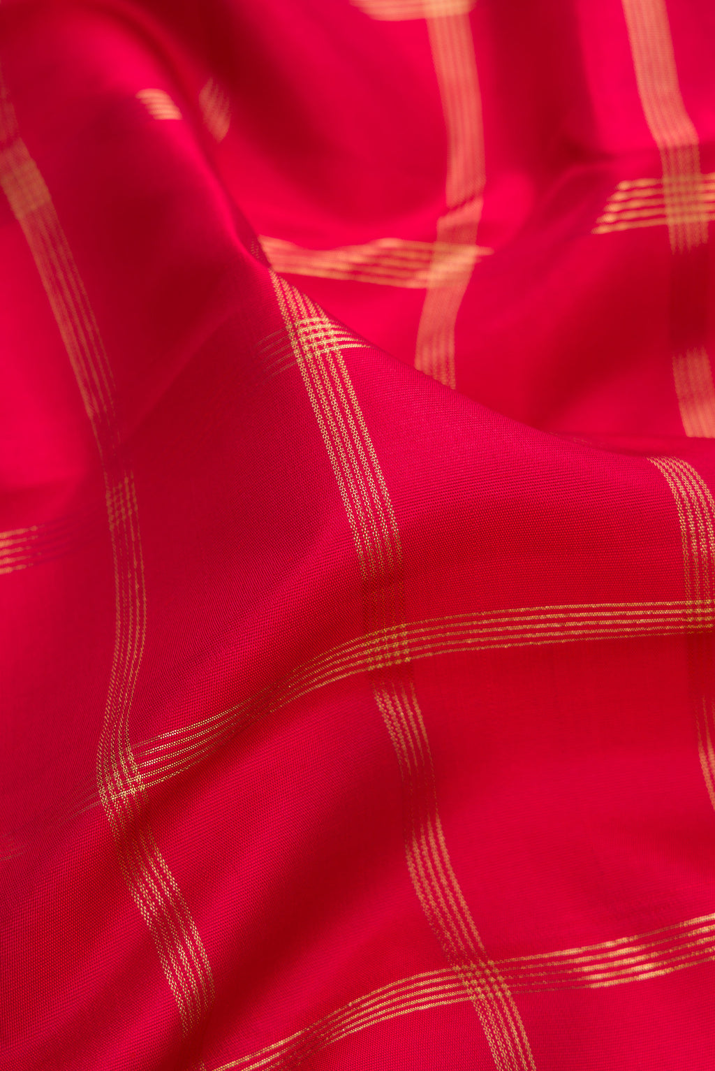 Close up of Pure Silk Pure Zari Red Kanjivaram Saree with Checked design on the body and Temple Border.  displaying folds