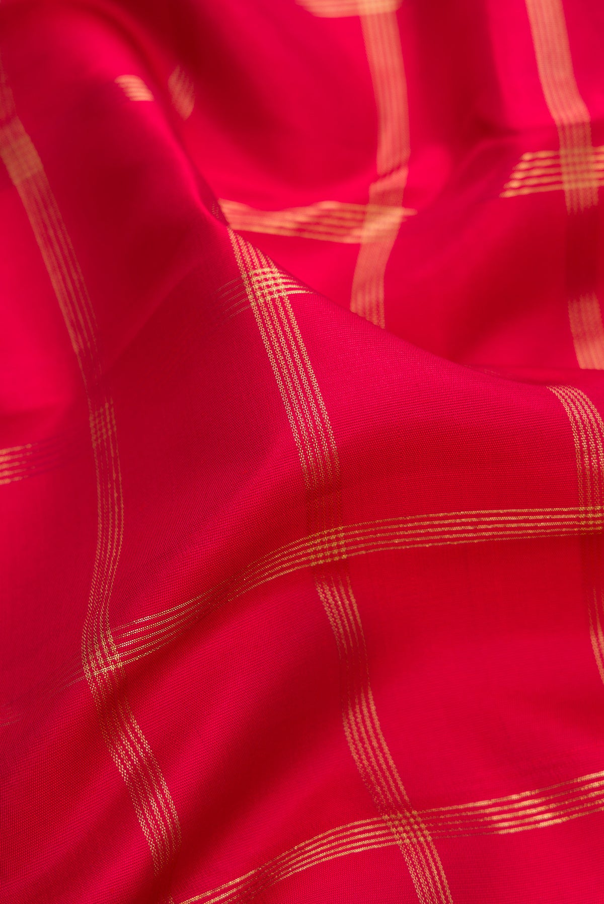 Close up of Pure Silk Pure Zari Red Kanjivaram Saree with Checked design on the body and Temple Border.  displaying folds