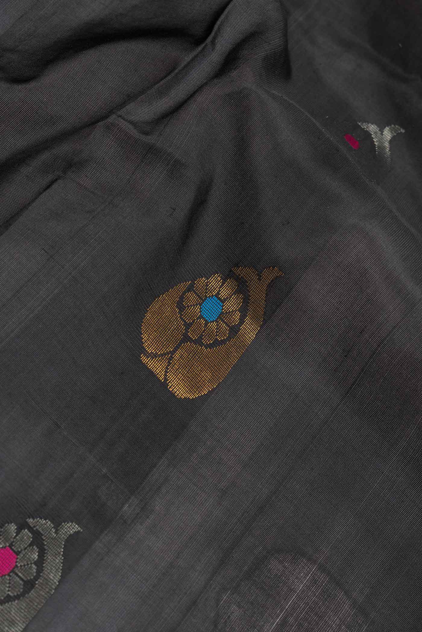 Close up of Black Dual Tone Uppada Silk Saree with Zari And Thread Butta on the body and Zari Border.  displaying folds