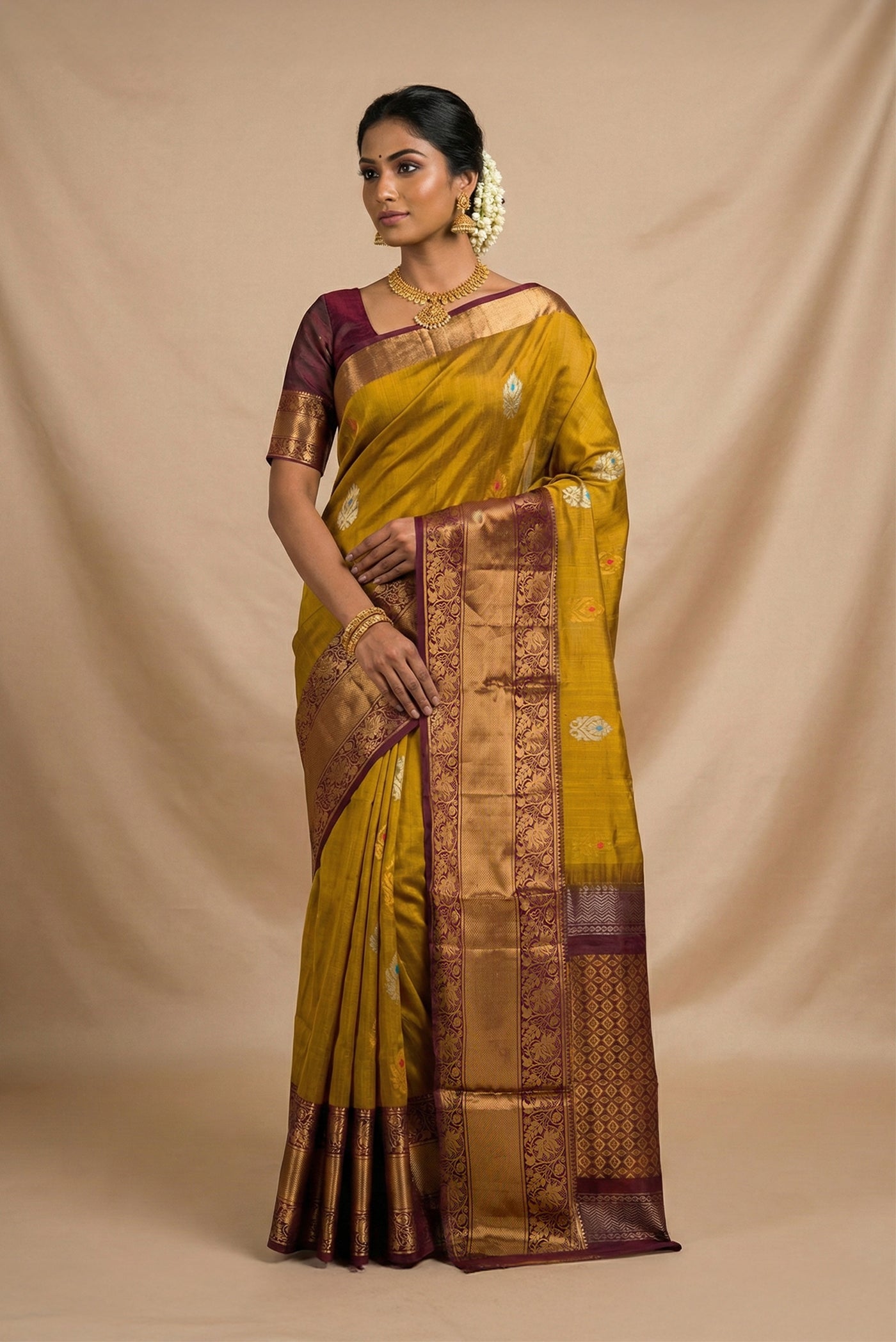Model wearing a Mehandi Green Dual Tone Uppada Silk Saree with Zari And Thread Butta on the body and Zari Border.