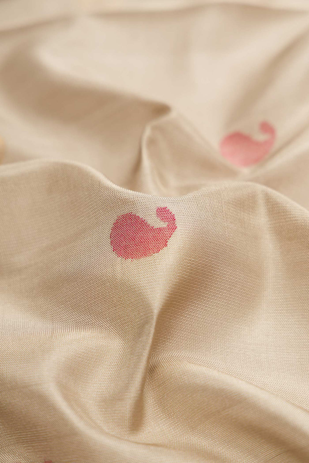 Close up of Beige Dual Tone Uppada Silk Saree with Zari And Thread Butta on the body and Zari Border.  displaying folds