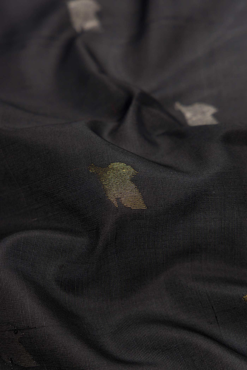 Close up of Black Dual Tone Uppada Silk Saree with Zari Butta on the body and Zari Border.  displaying folds