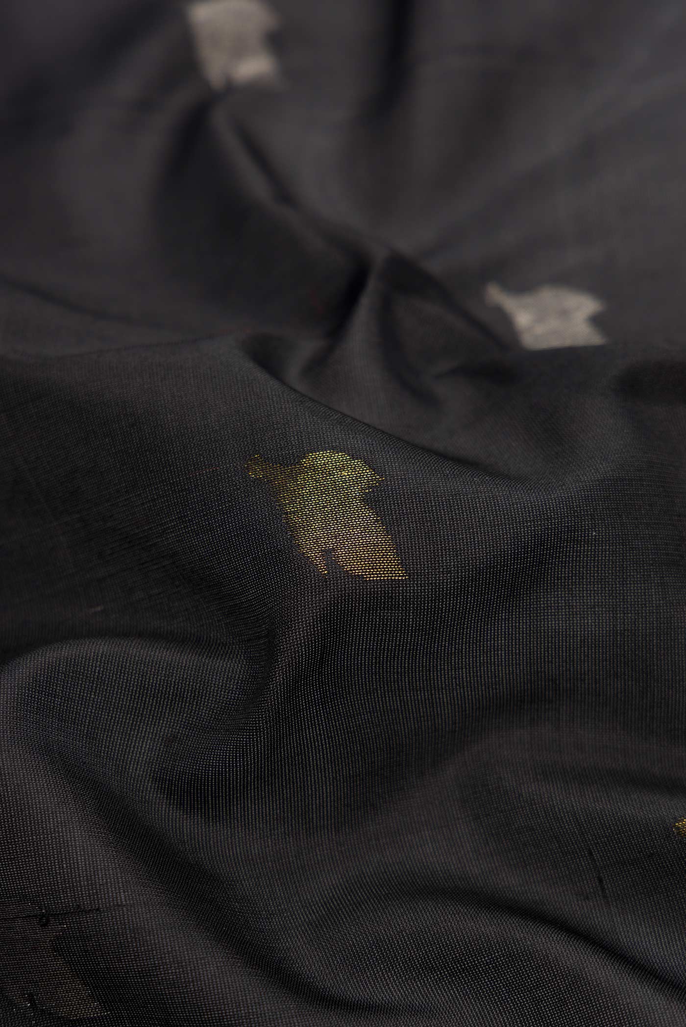 Close up of Black Dual Tone Uppada Silk Saree with Zari Butta on the body and Zari Border.  displaying folds