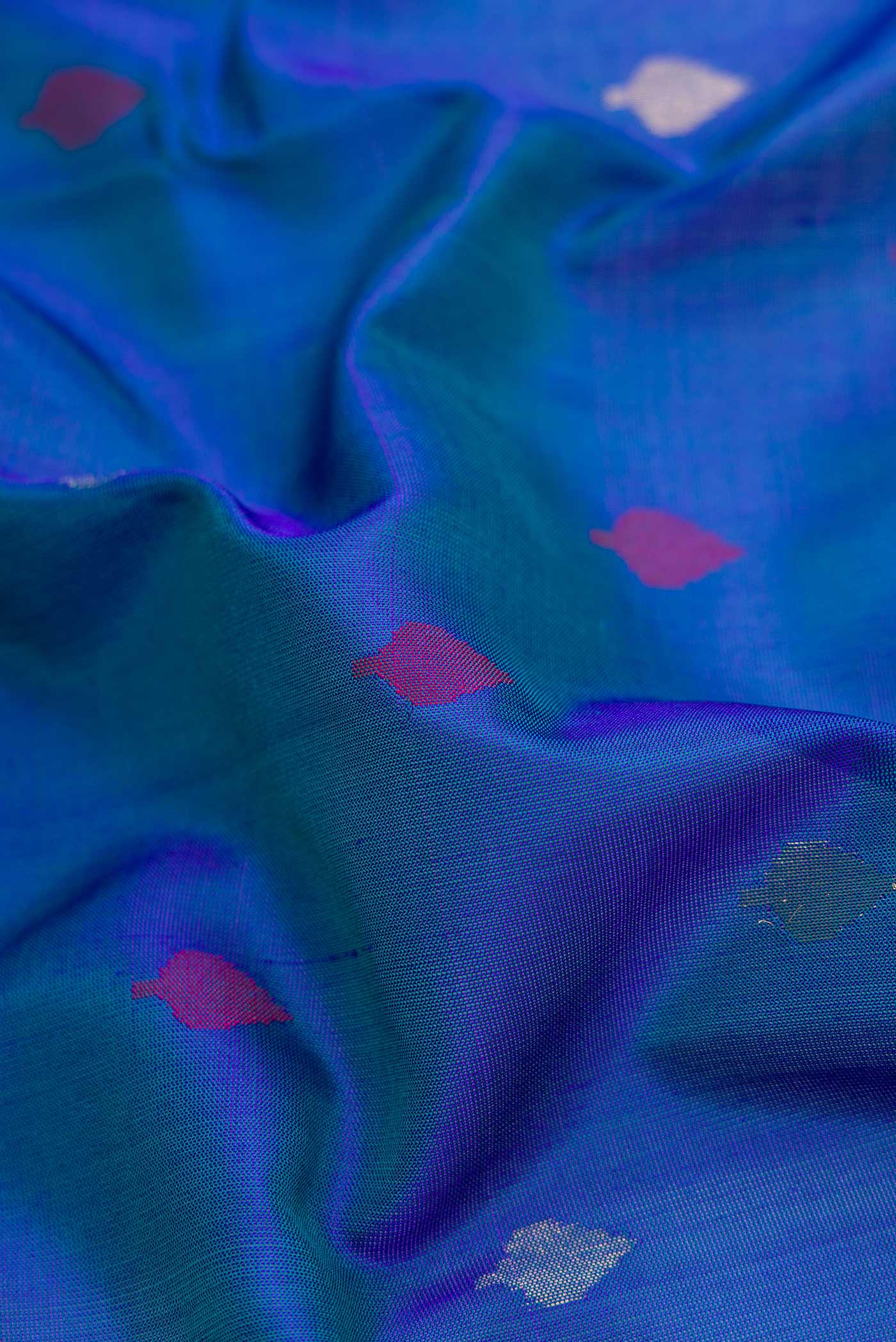 Close up of Peacock Blue Dual Tone Uppada Silk Saree with Zari And Thread Butta on the body and Zari Border.  displaying folds