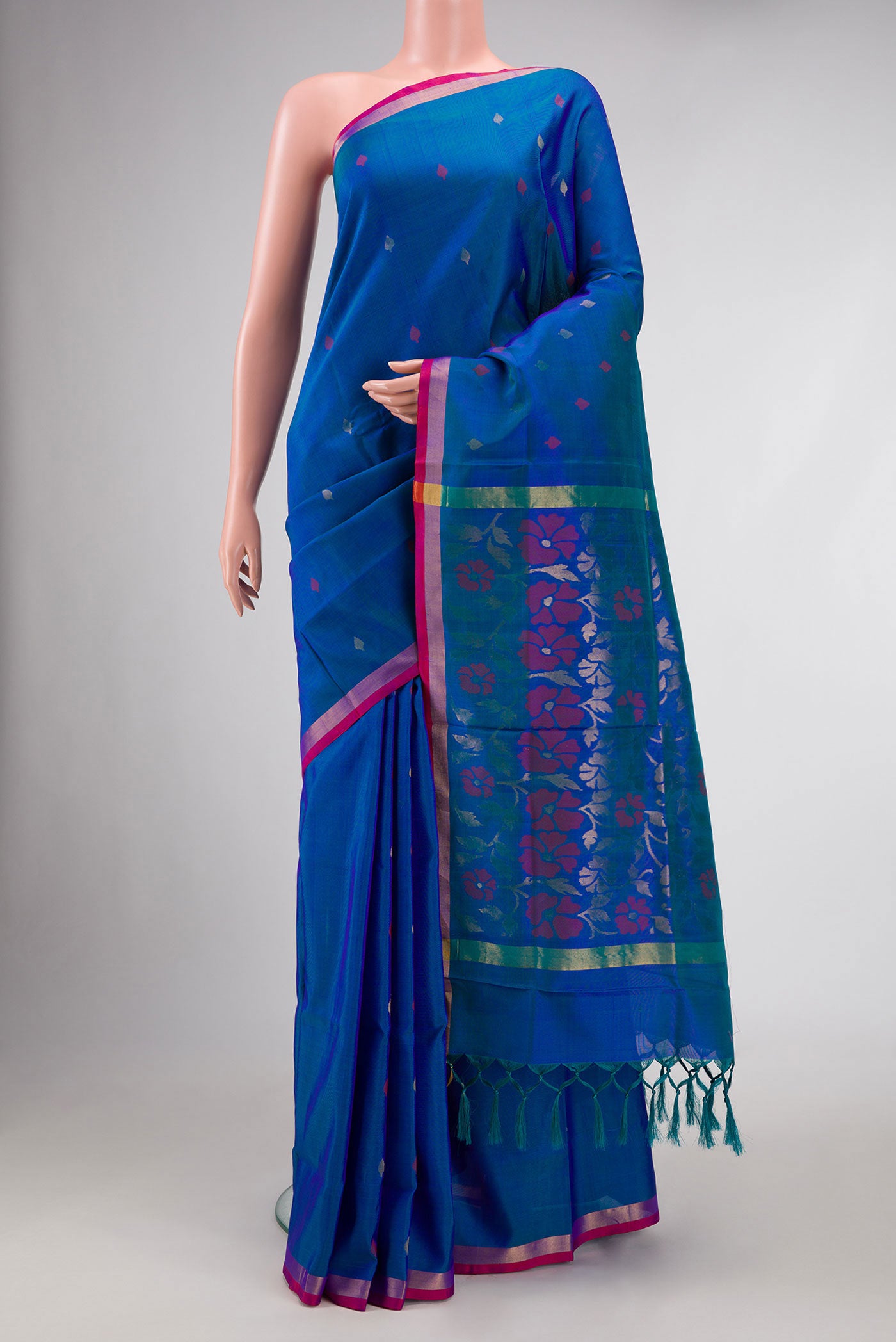 Peacock Blue Dual Tone Uppada Silk Saree with Zari And Thread Butta on the body and Zari Border.  displayed on a mannequin
